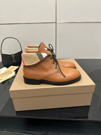 Tan lace-up shoe with black sole and plaid fabric collar