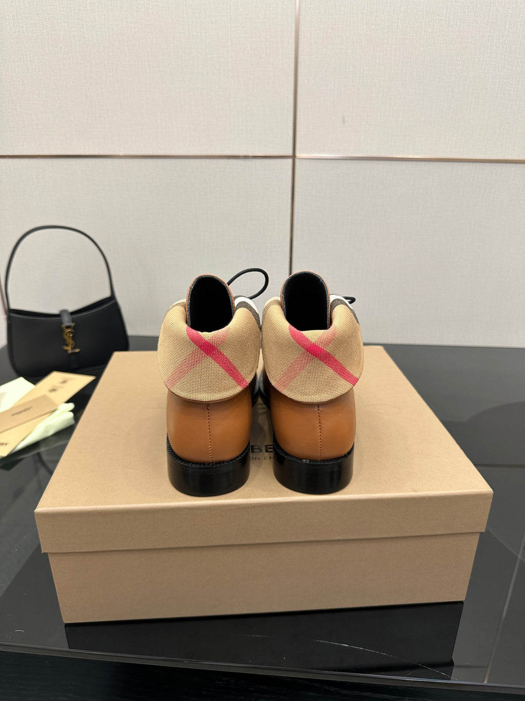 Tan lace-up shoes shown from the back with plaid heel collar and black soles