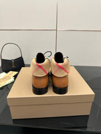 Tan lace-up shoes shown from the back with plaid heel collar and black soles