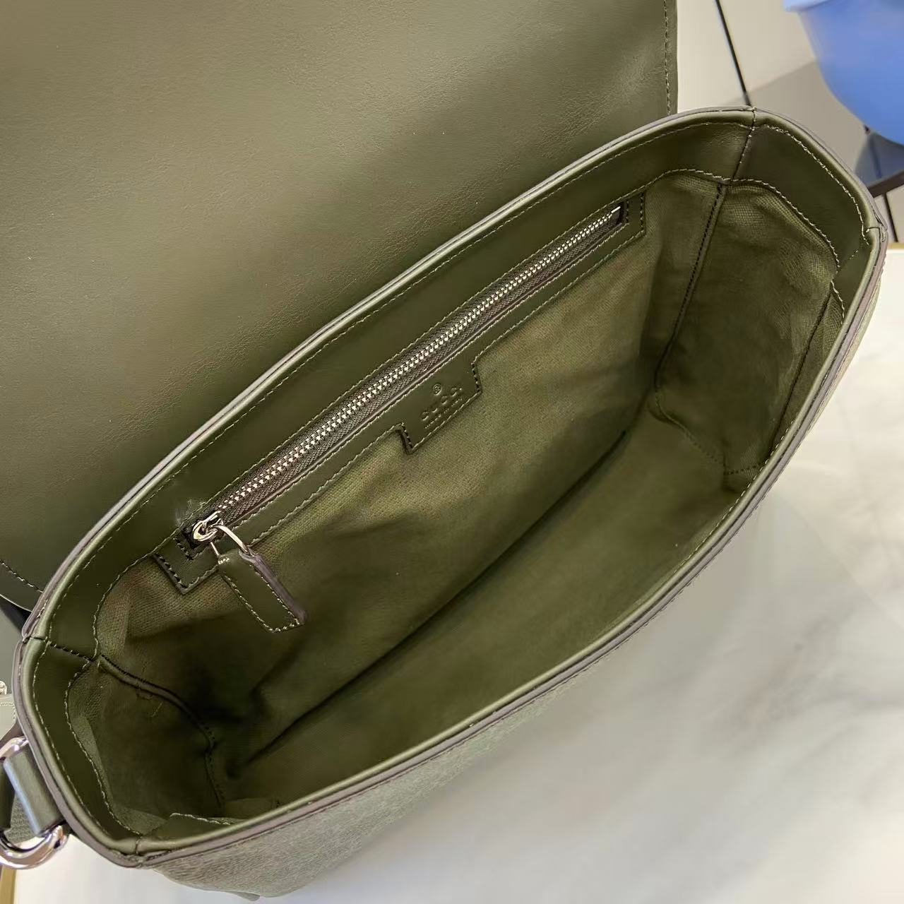 Gucci bag interior view with zippered pocket and green fabric lining