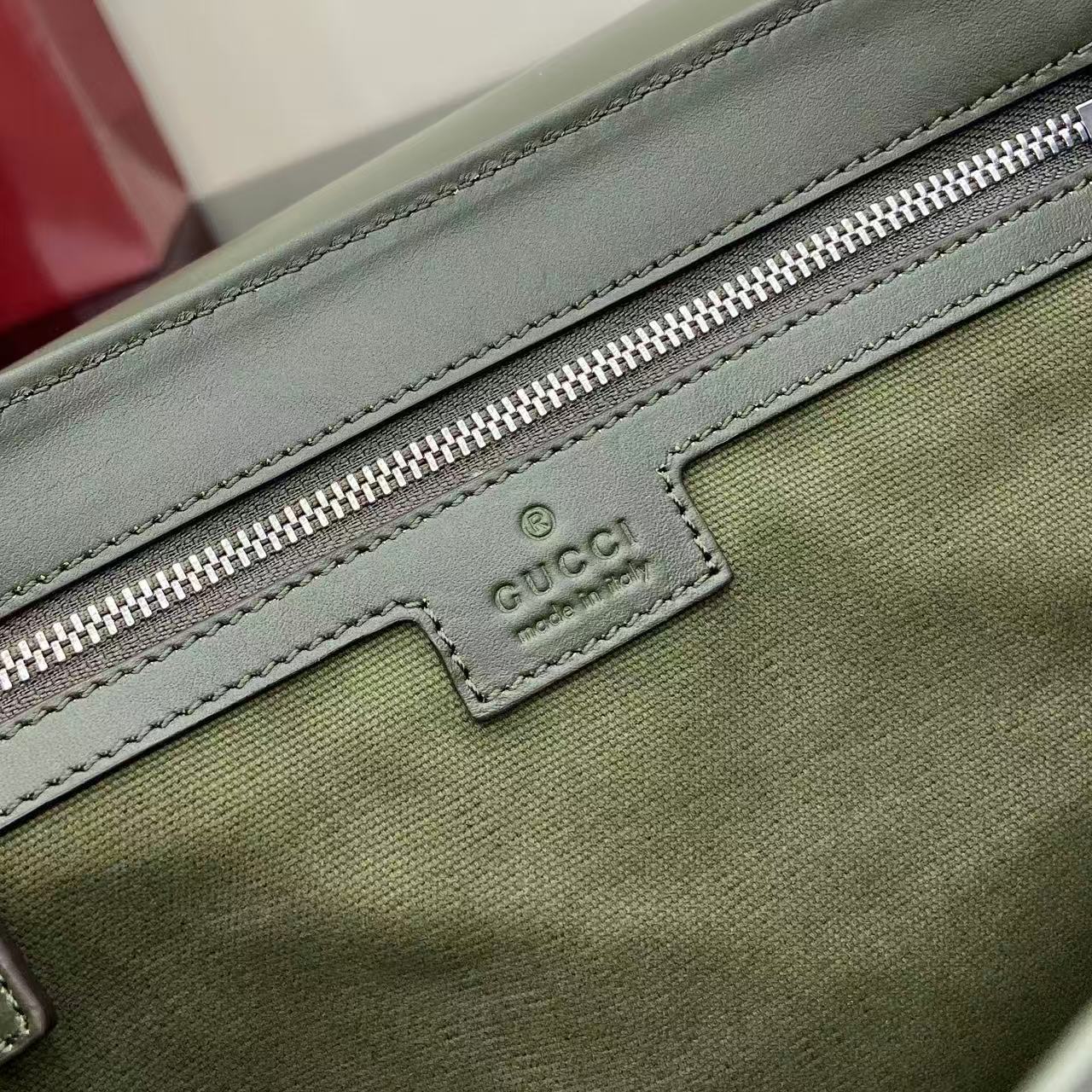 Gucci logo patch on green zip pocket with silver zipper and stitched border