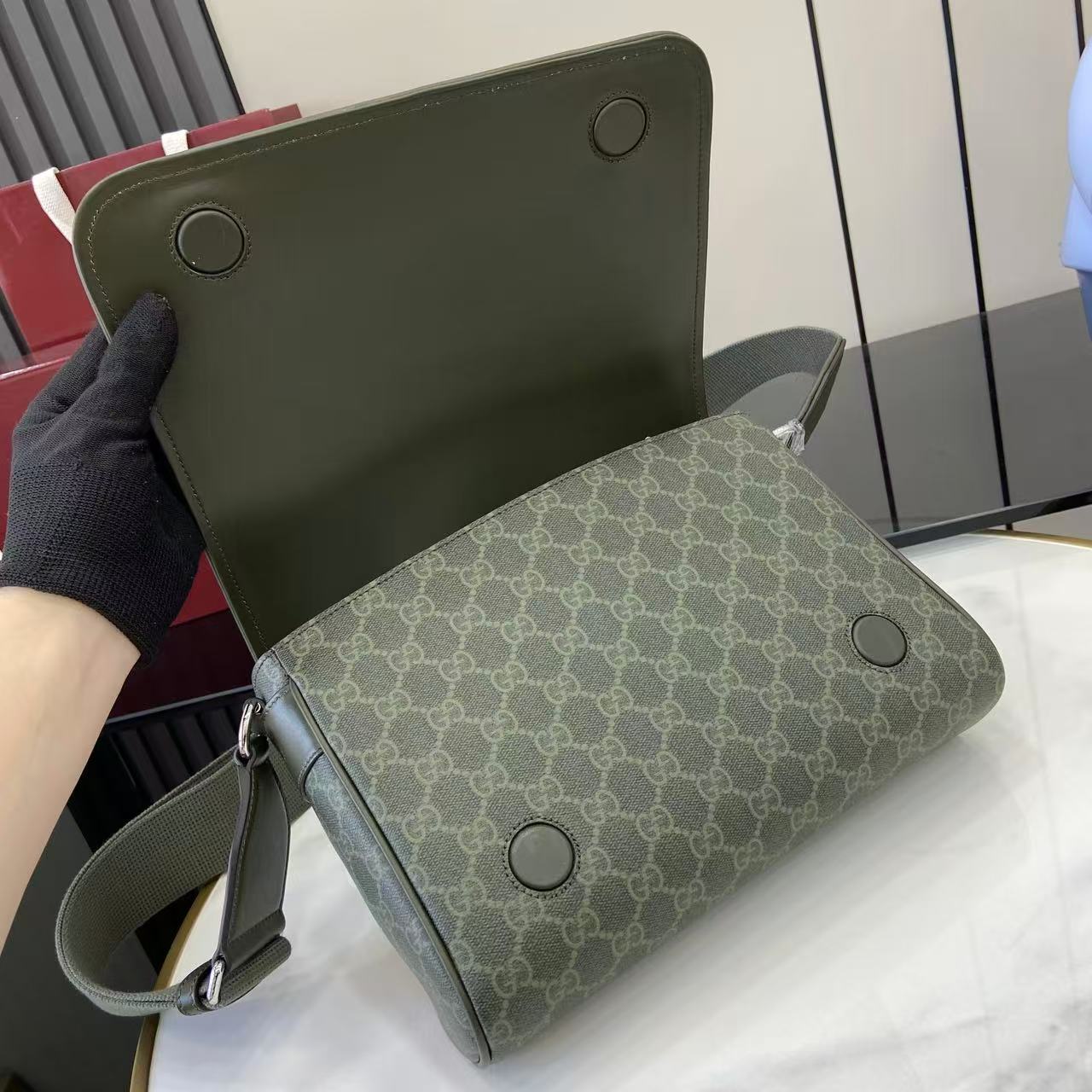 Gucci GG monogram bag with leather back panel, round studs, and shoulder strap