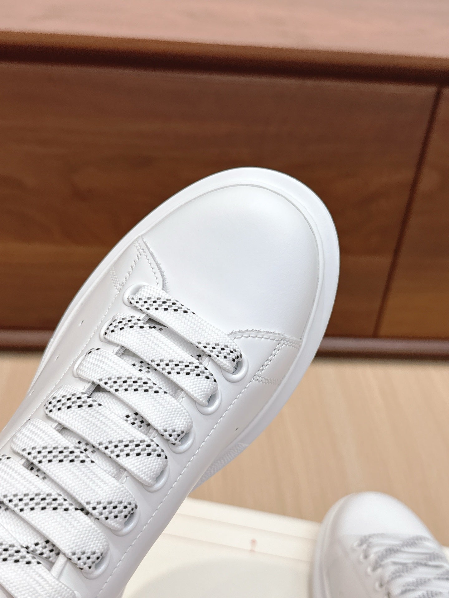 White leather sneaker toe and lace-up front with perforated eyelets