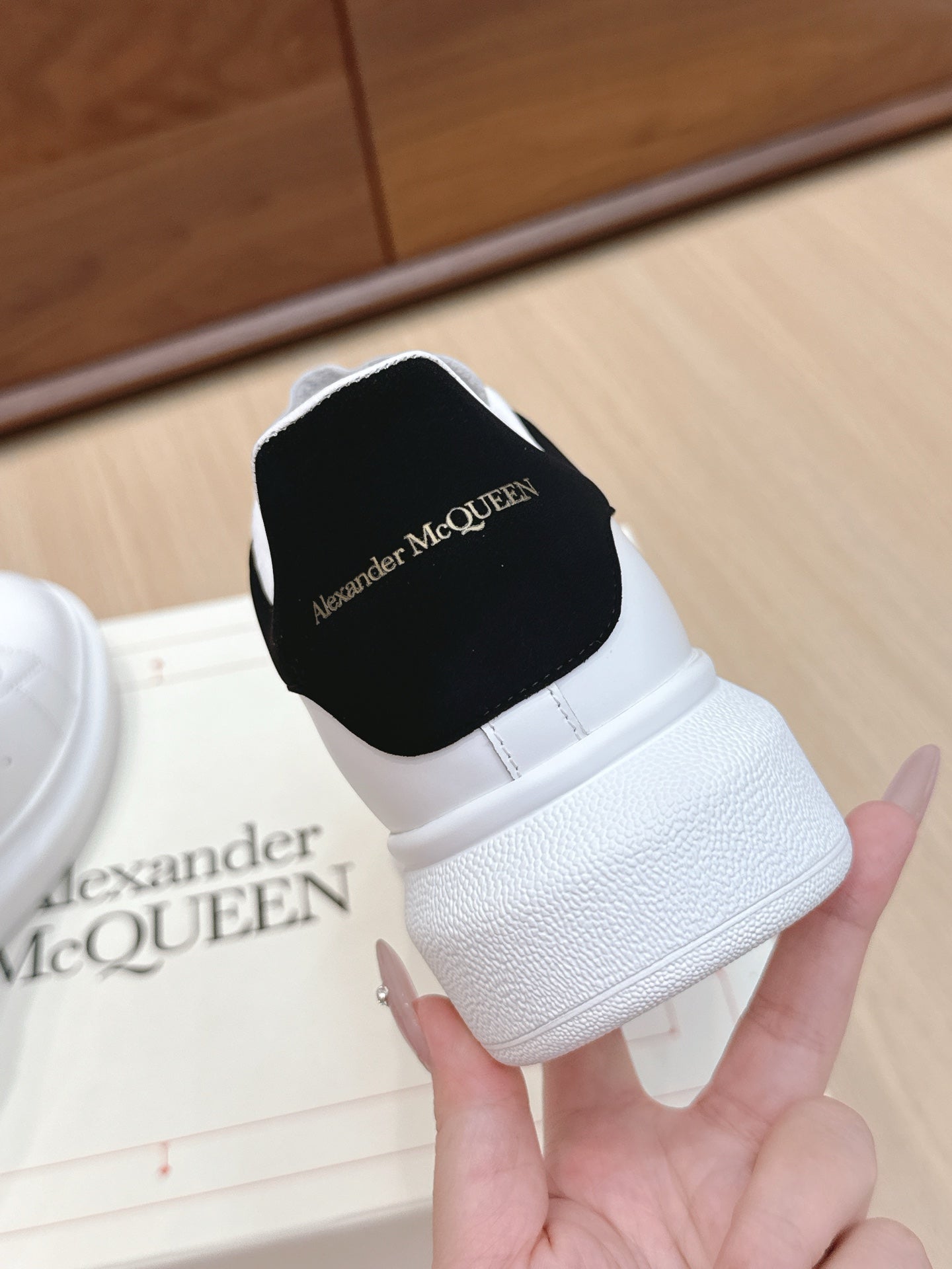 White leather low-top sneaker with black heel patch and side stitching