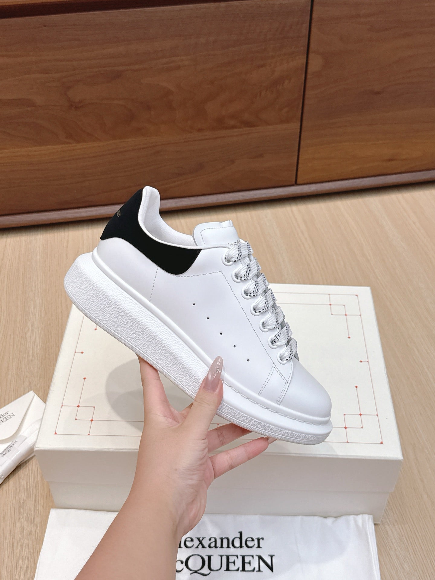 White leather low-top sneaker with black heel panel and lace-up design