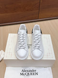 Pair of white leather sneakers with black heel accents and white laces