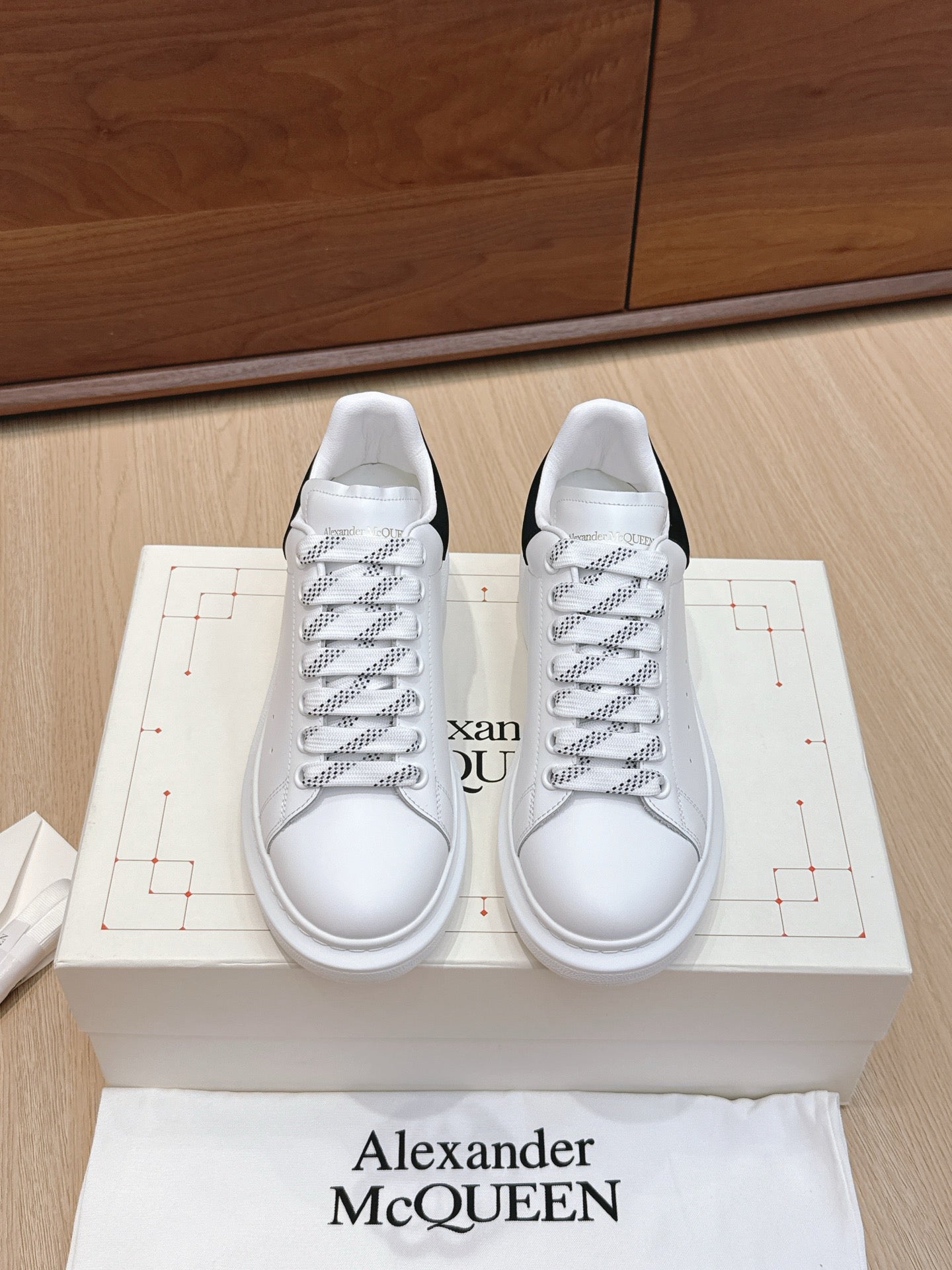 Pair of white leather sneakers with black heel accents and white laces