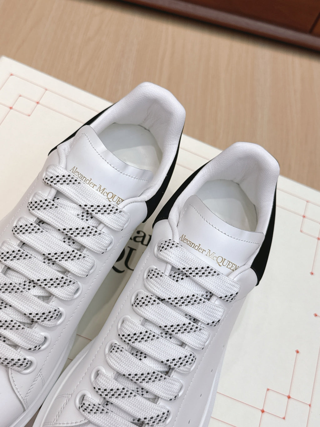 White leather sneakers with perforated lace-up panels and padded tongue