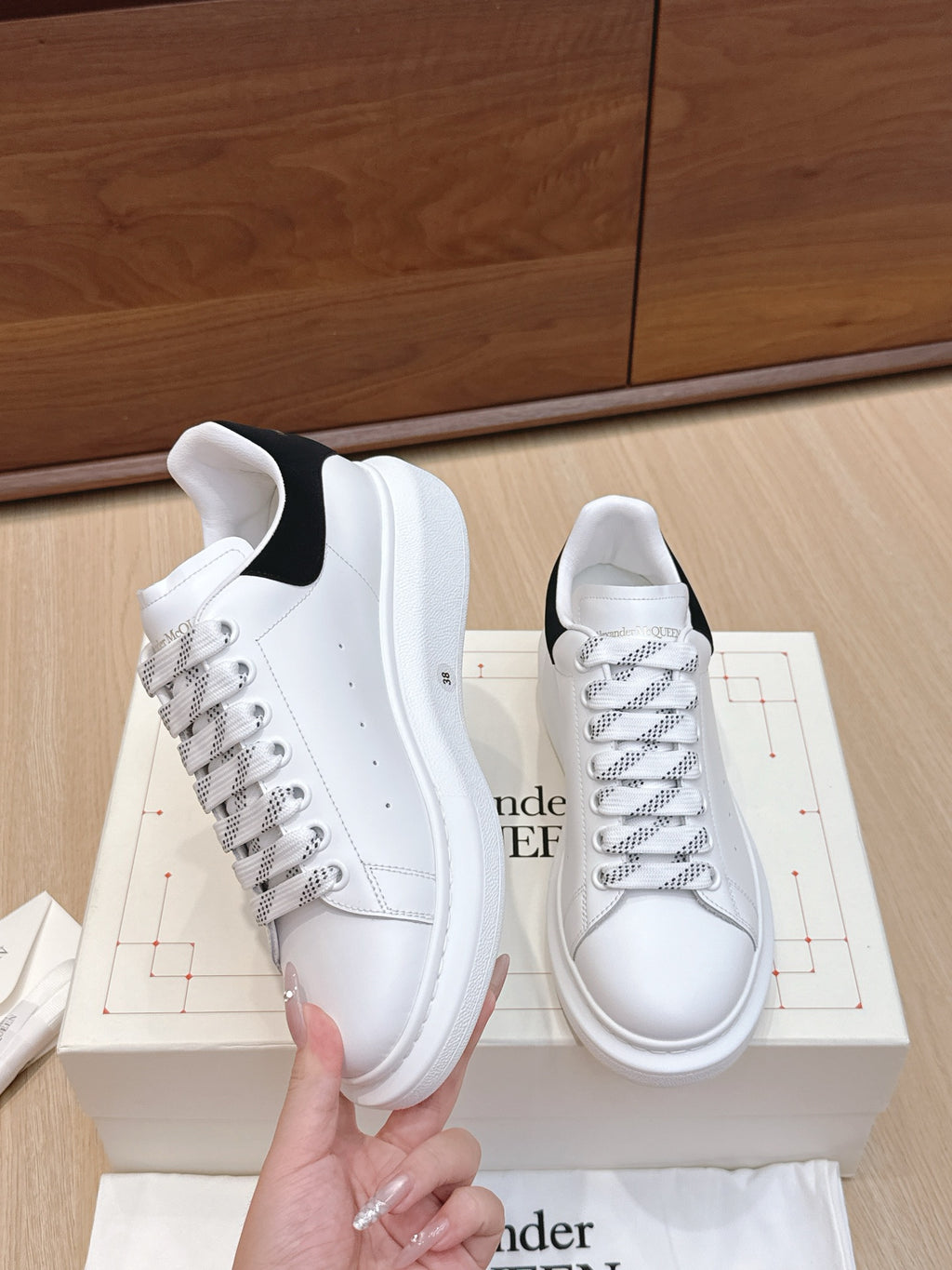 White leather low-top sneakers with black heel panel and textured sole
