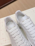 Alexander McQueen white leather sneakers, close-up of heel and lace-up tongue