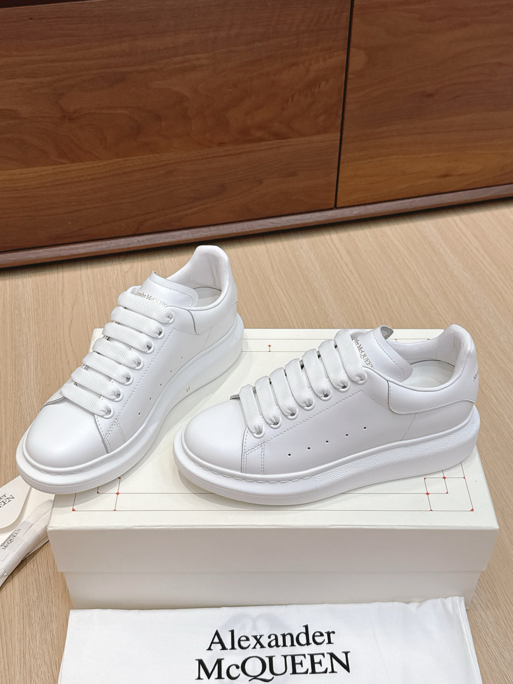 Alexander McQueen white leather sneakers, pair front/side view with round toe and laces