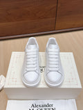 Alexander McQueen white leather sneakers, front view on box with lace-up design