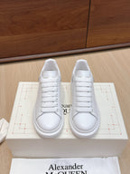 Alexander McQueen white leather sneakers, front view on box with lace-up design