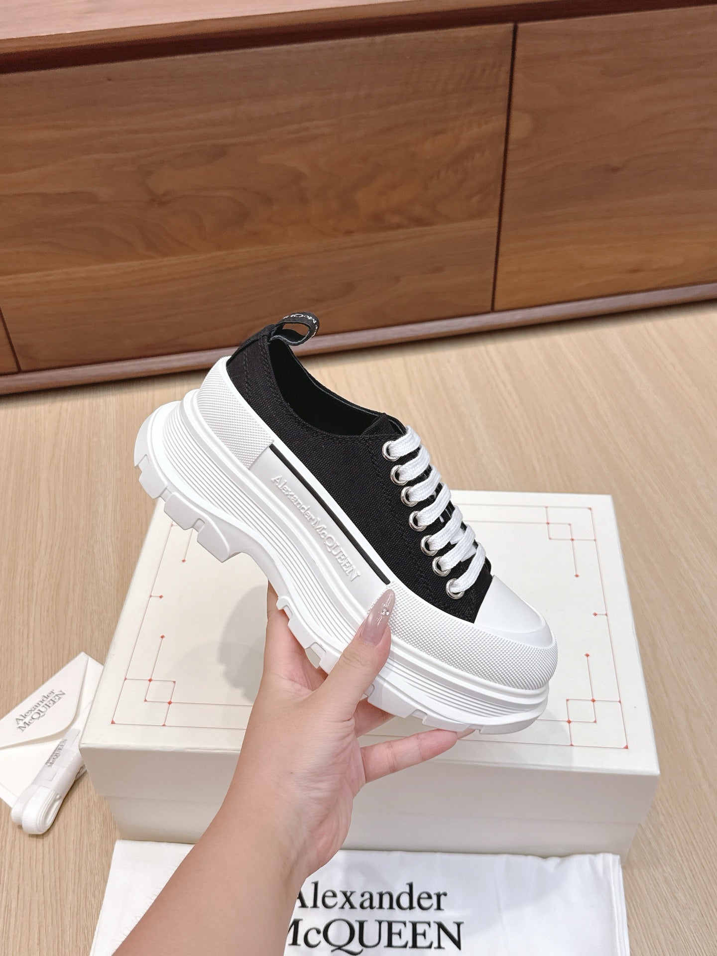 Black and white low-top lace-up sneakers with chunky white sole