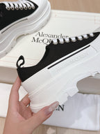 Black low-top sneaker with white laces and white platform midsole