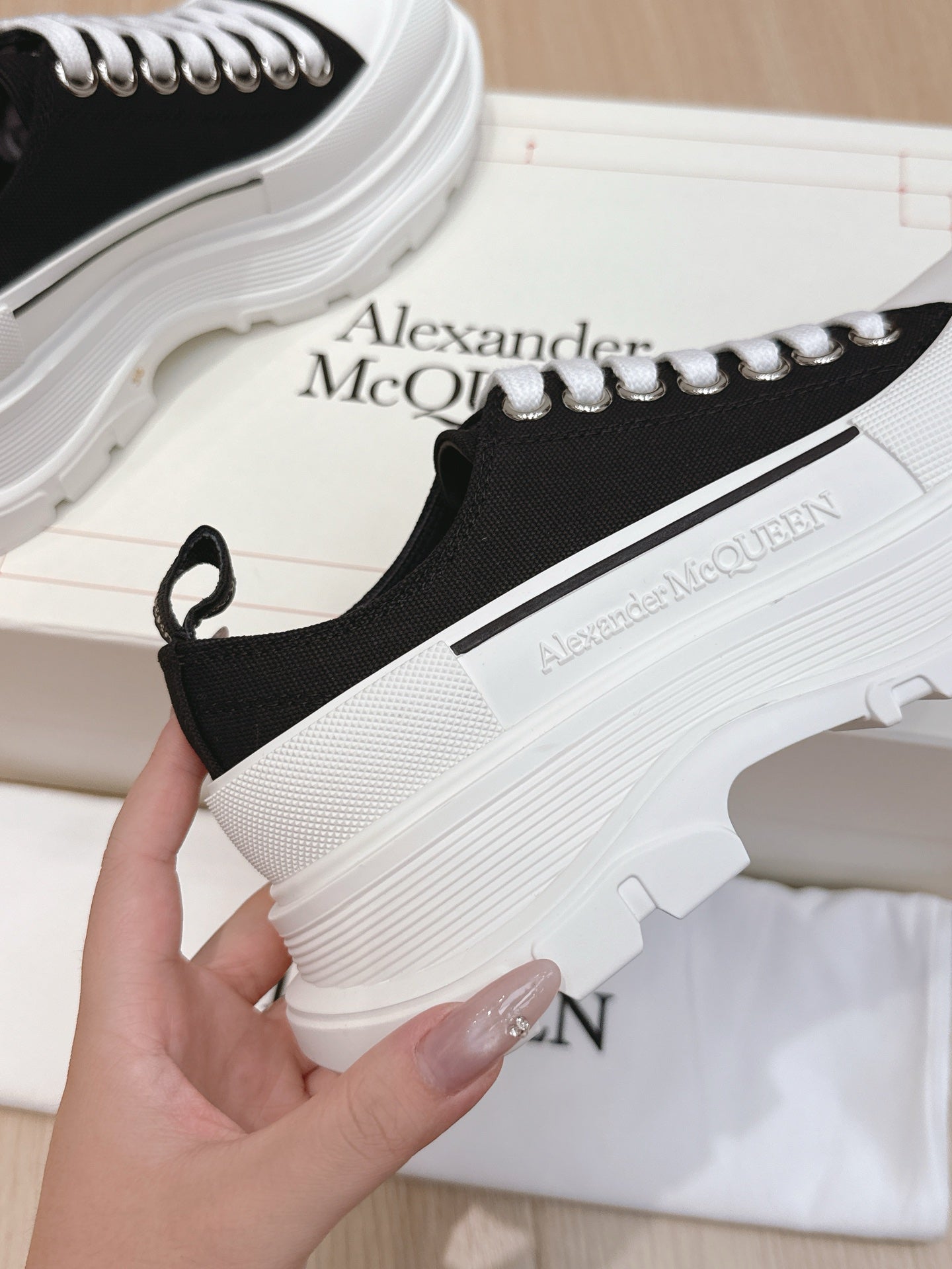Black low-top sneaker with white laces and white platform midsole
