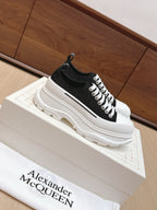Black and white low-top lace-up sneakers with thick white platform sole