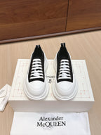 Pair of black-and-white low-top lace-up sneakers with white rubber soles