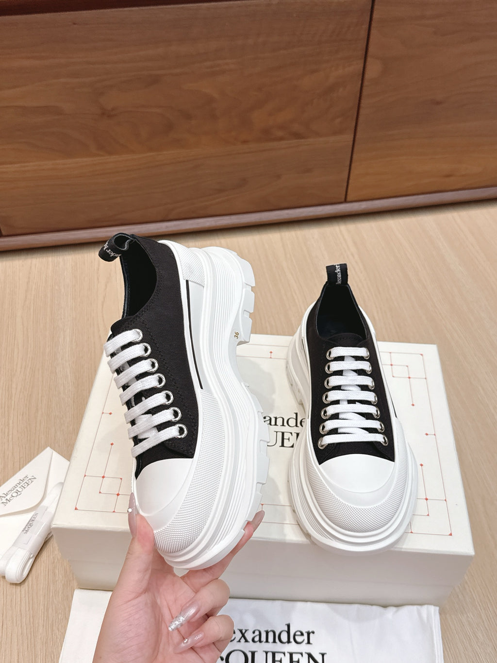 Black and white low-top sneakers with white laces and platform sole