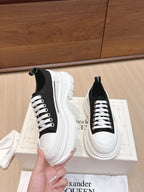 Black and white low-top sneakers with white laces and platform sole