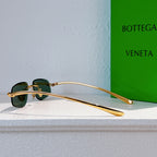 Bottega Veneta sunglasses with gold frame and dark green tinted lenses, profile view