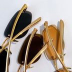 Bottega Veneta sunglasses gold frames with tinted lenses, hinge and temple close-up