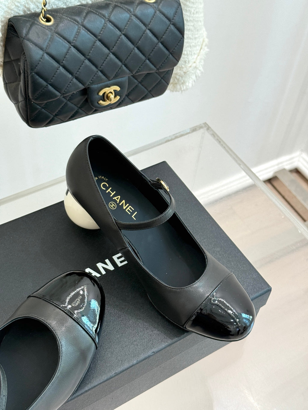 Black Mary Jane pumps with silver patent toe, round white heel, and strap buckle