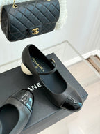 Black Mary Jane pumps with silver patent toe, round white heel, and strap buckle