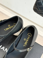 Black Mary Jane pumps with silver patent toe cap and gold buckle