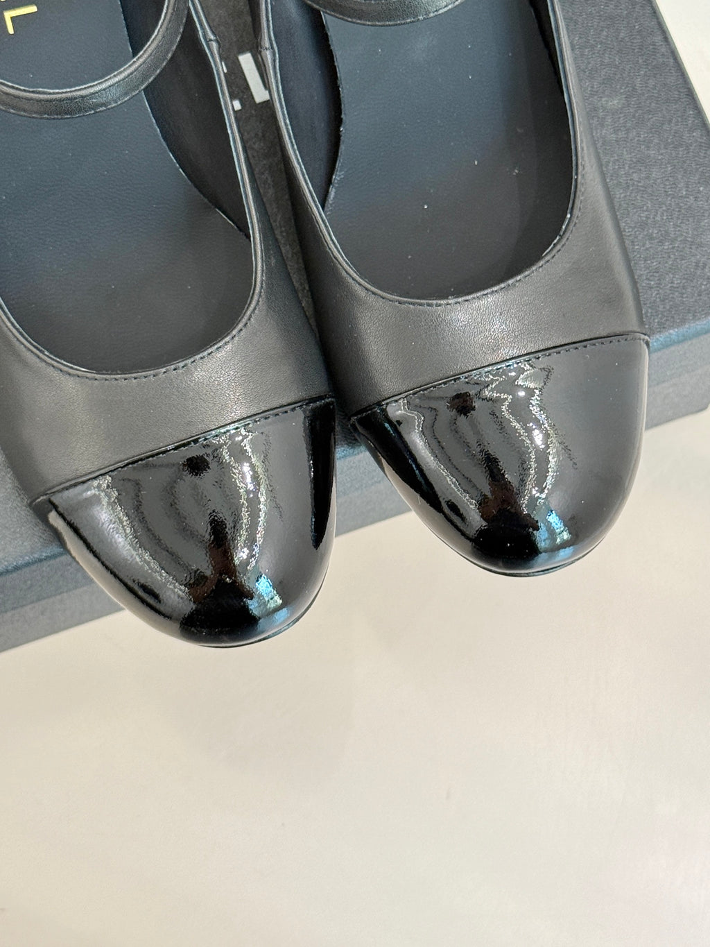 Black leather pumps with glossy silver patent toe detail