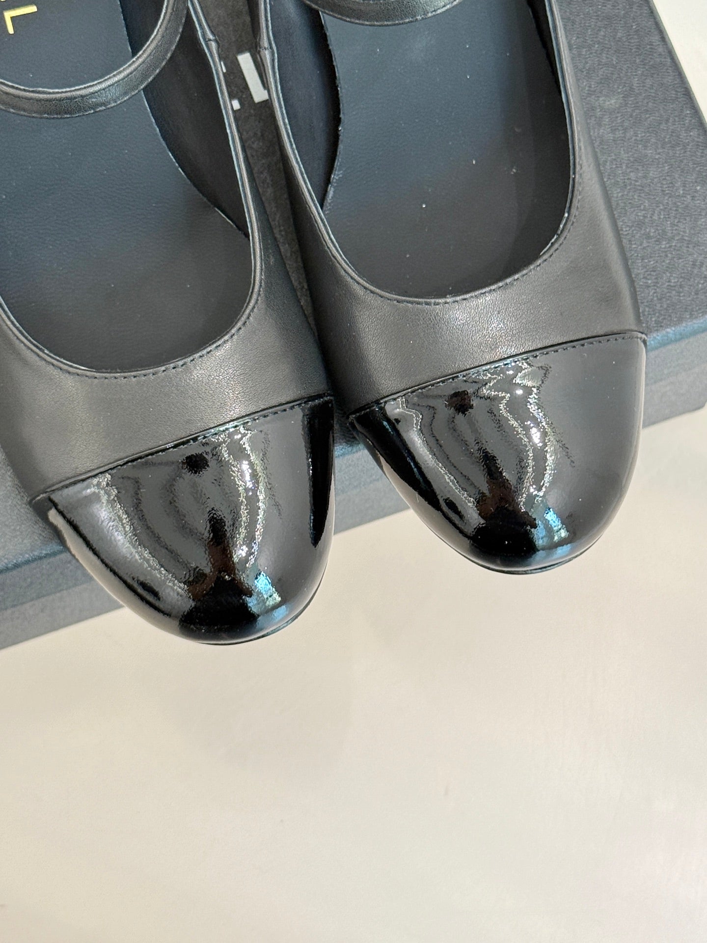 Black leather pumps with glossy silver patent toe detail