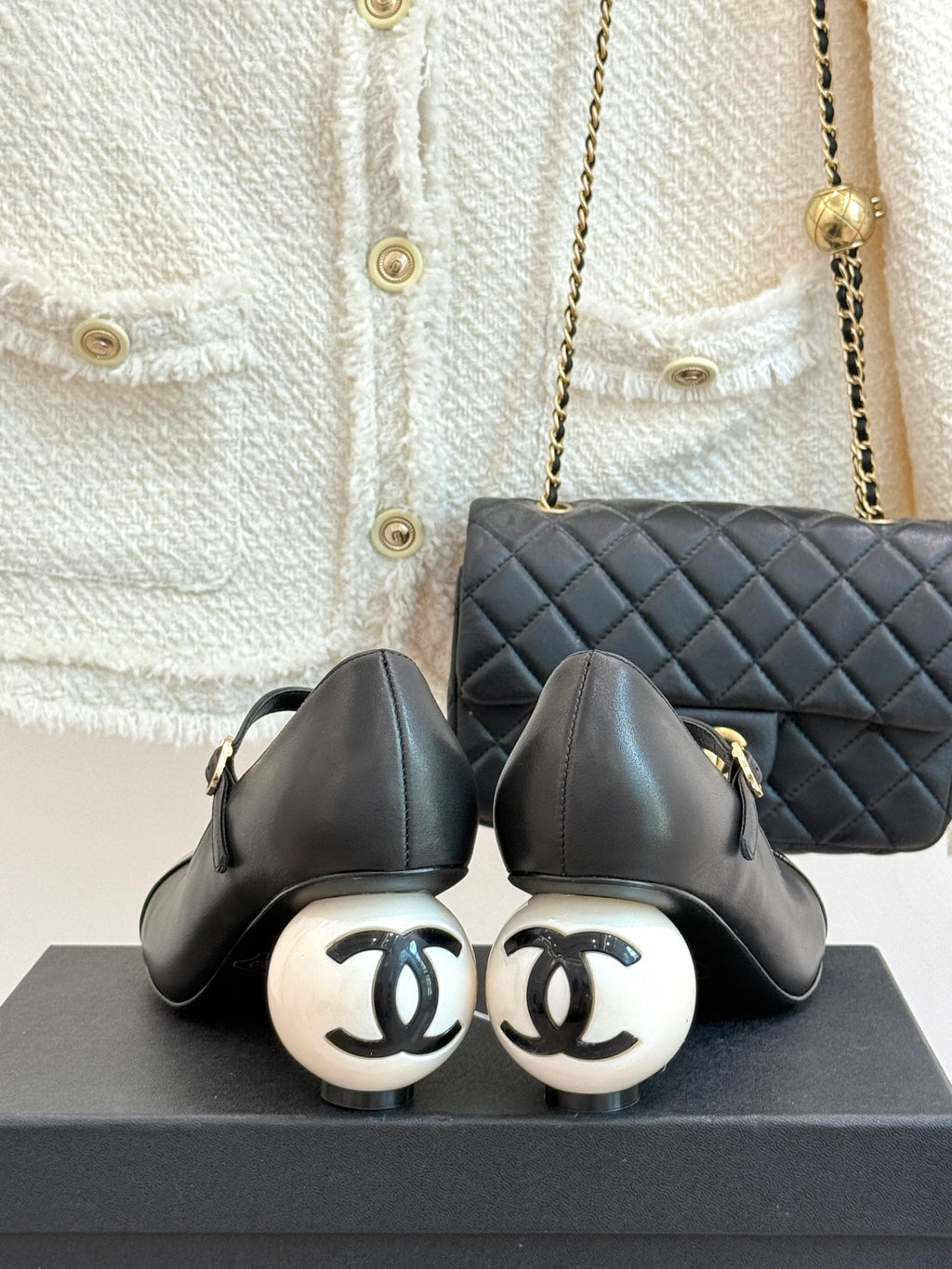 Pair of black pumps with round white heel caps and ankle strap