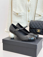 Black Mary Jane pumps with silver patent toe cap and round white heel accents