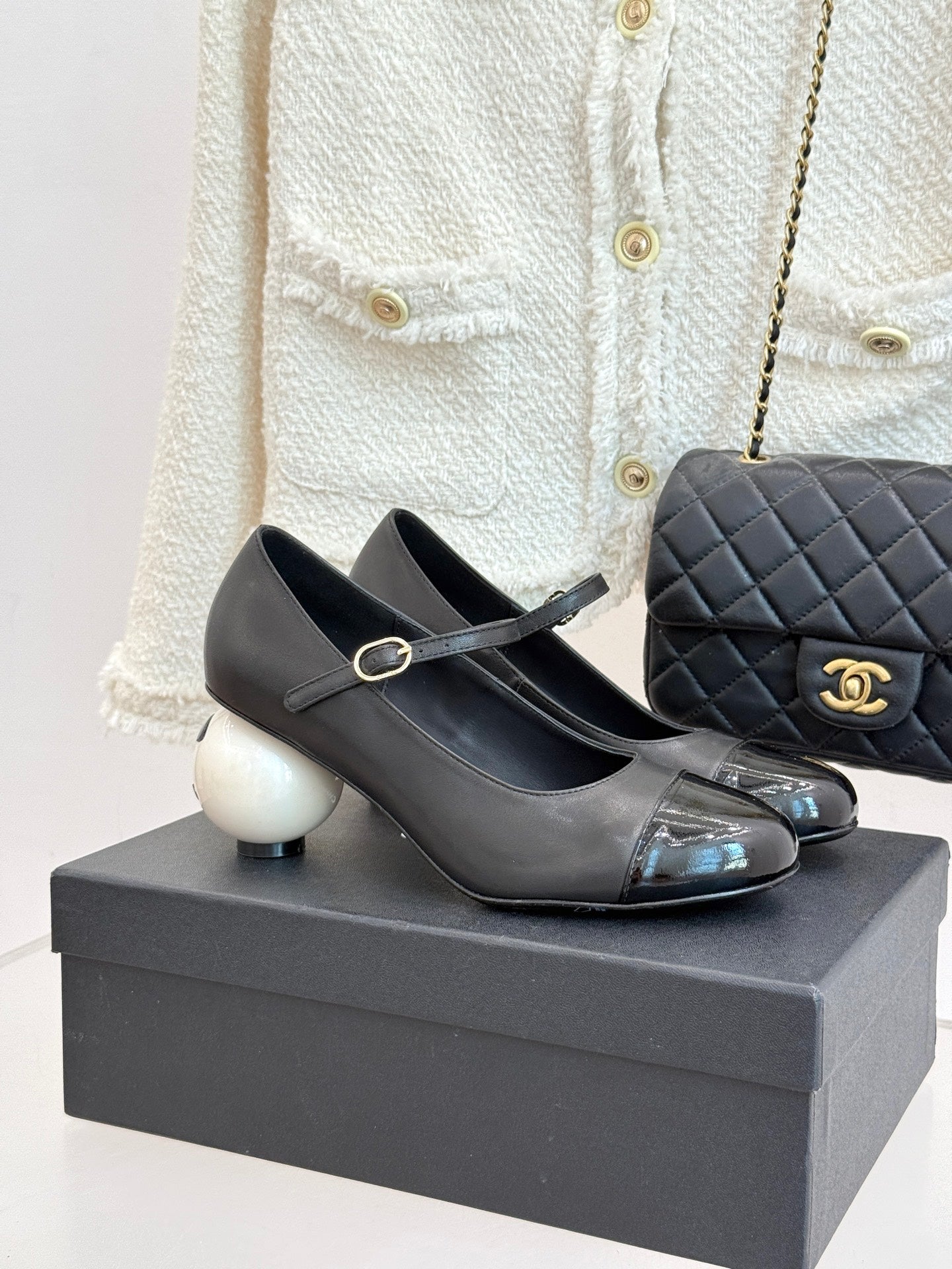 Black Mary Jane pumps with silver patent toe cap and round white heel accents