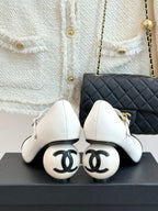 Chanel women's shoes with CC-logo soles, white leather uppers and black toe