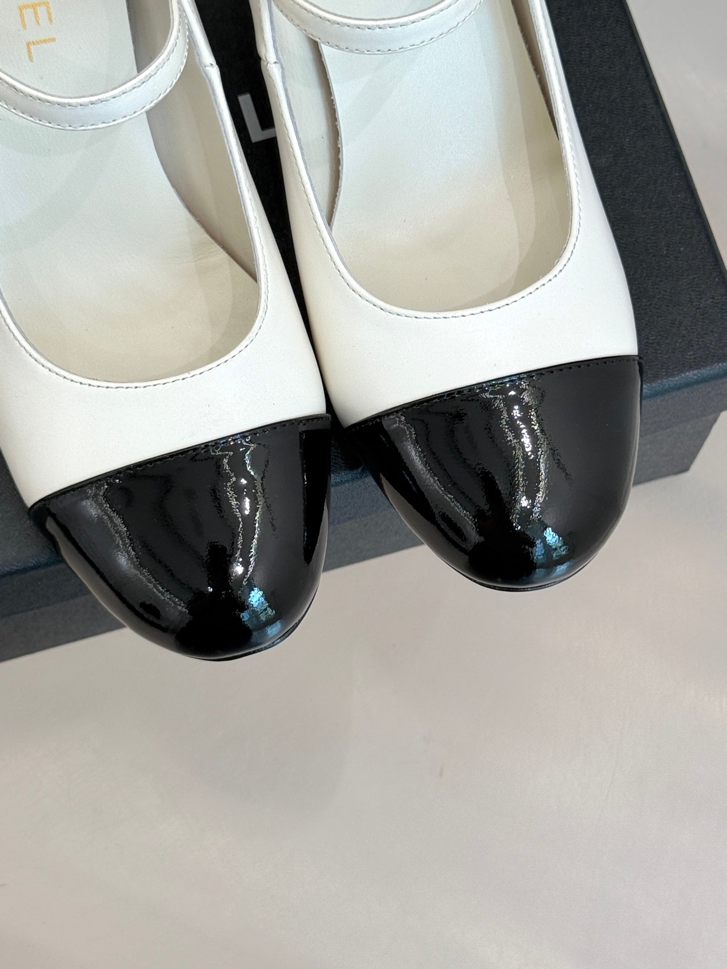 Chanel women's two-tone flats close-up, white leather with black patent toe
