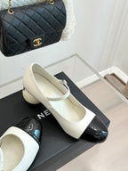 Chanel women's flats pair, white uppers with black patent toe on a box