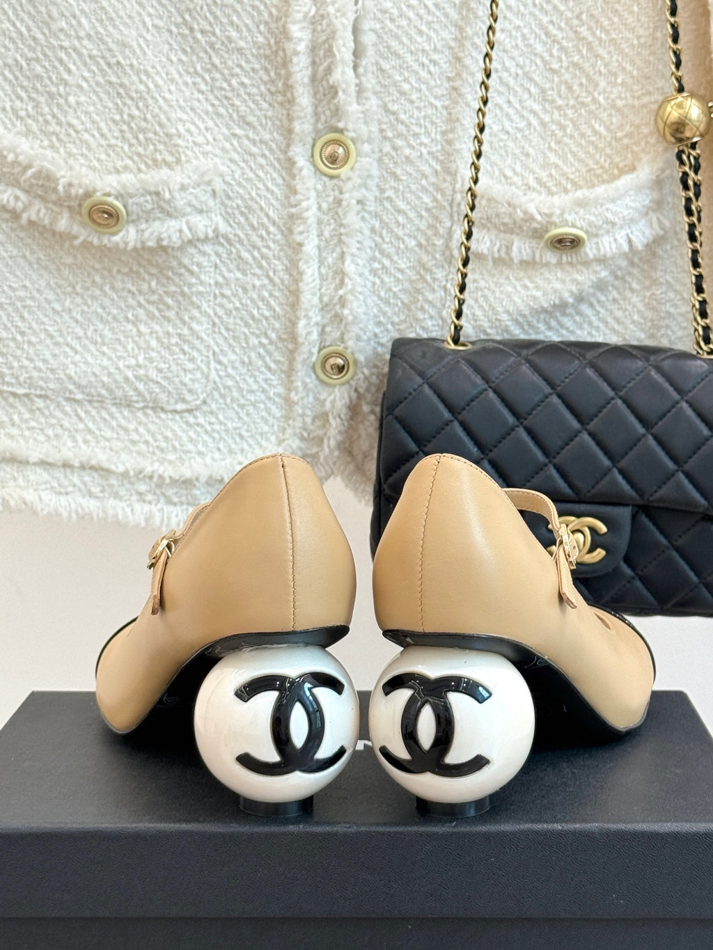 Beige Chanel flats with heel detail and glossy black accent at toe