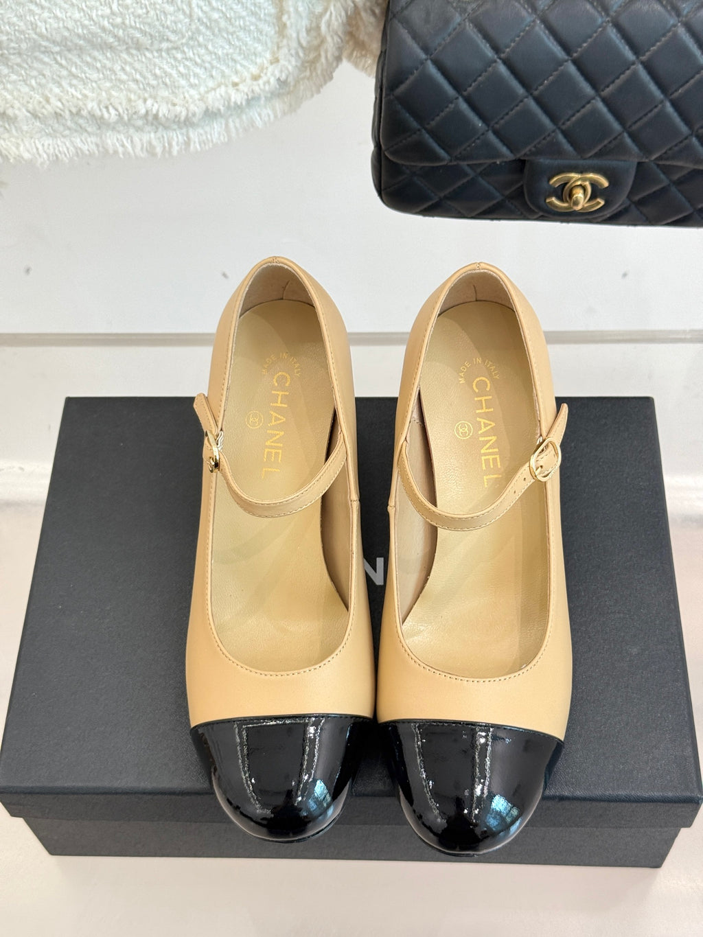 Pair of Chanel flats with beige leather uppers and glossy black toe inserts