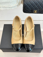 Pair of Chanel flats with beige leather uppers and glossy black toe inserts