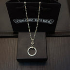 Silver-tone chain necklace with circular ring pendant, displayed on a black jewelry box.