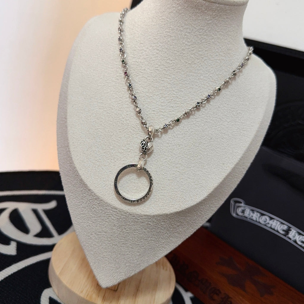 Silver-tone chain necklace with circular ring charm pendant, shown on bust display.