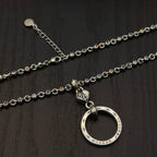 Silver-tone chain necklace with circular ring pendant; cross-studded details on links.