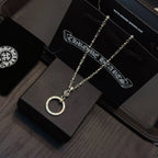 Silver-tone necklace with circular ring pendant laid on a dark jewelry display tray.