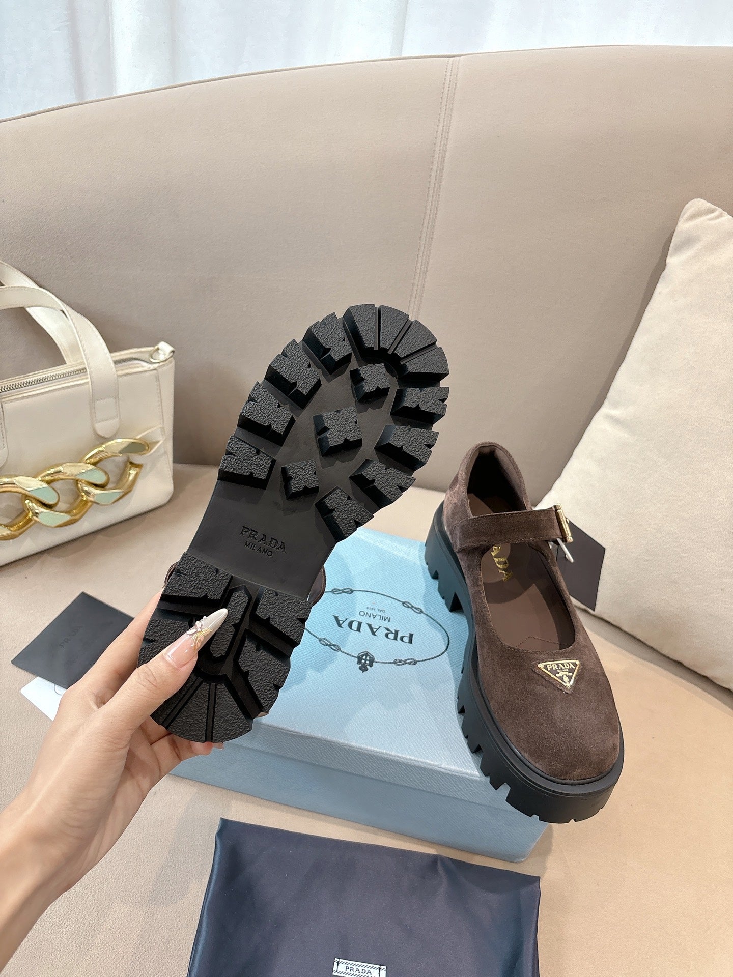 Prada women’s suede shoes, brown, outsole view with lug tread and logo.