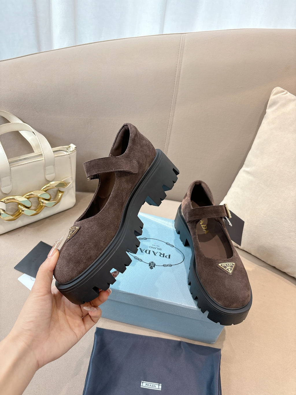 Prada women’s suede buckle loafers, brown, side profile with chunky tread sole.