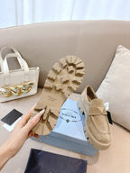 Beige suede loafer mules with strap; visible tread outsole, Prada