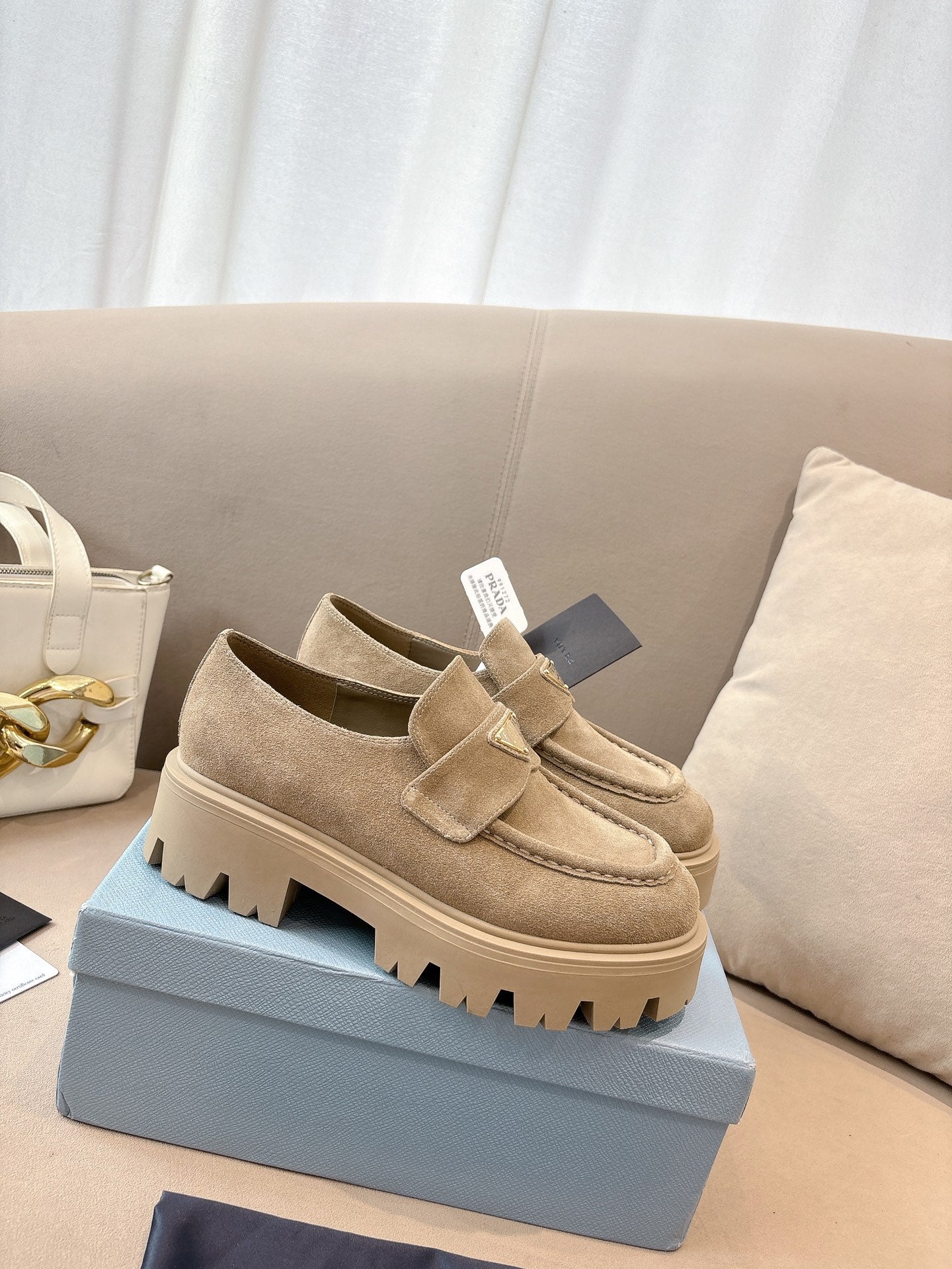 Beige suede loafer mules with buckle strap and thick tread sole, Prada