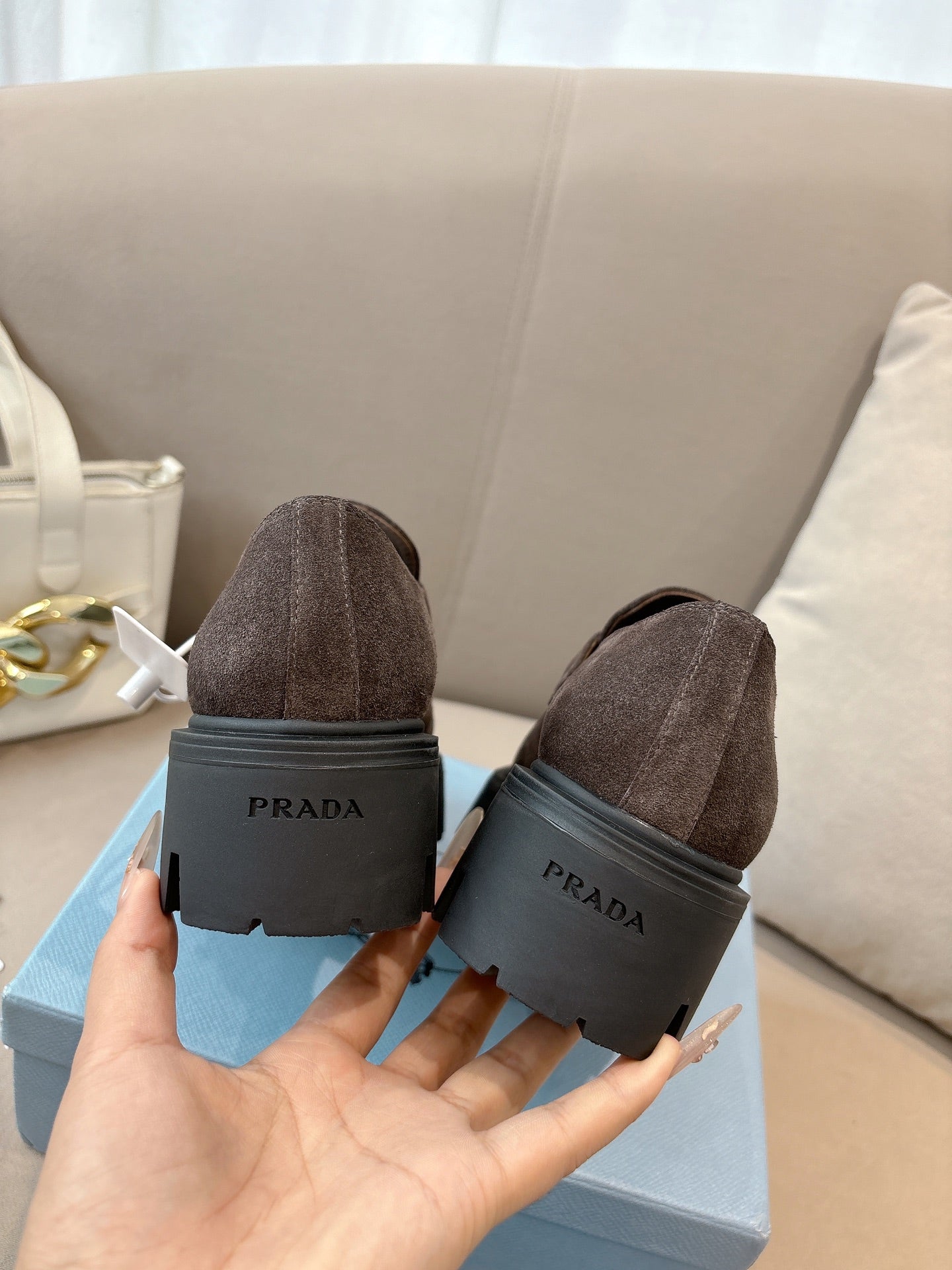 Dark brown suede loafers, heel view with logo print on rubber sole block