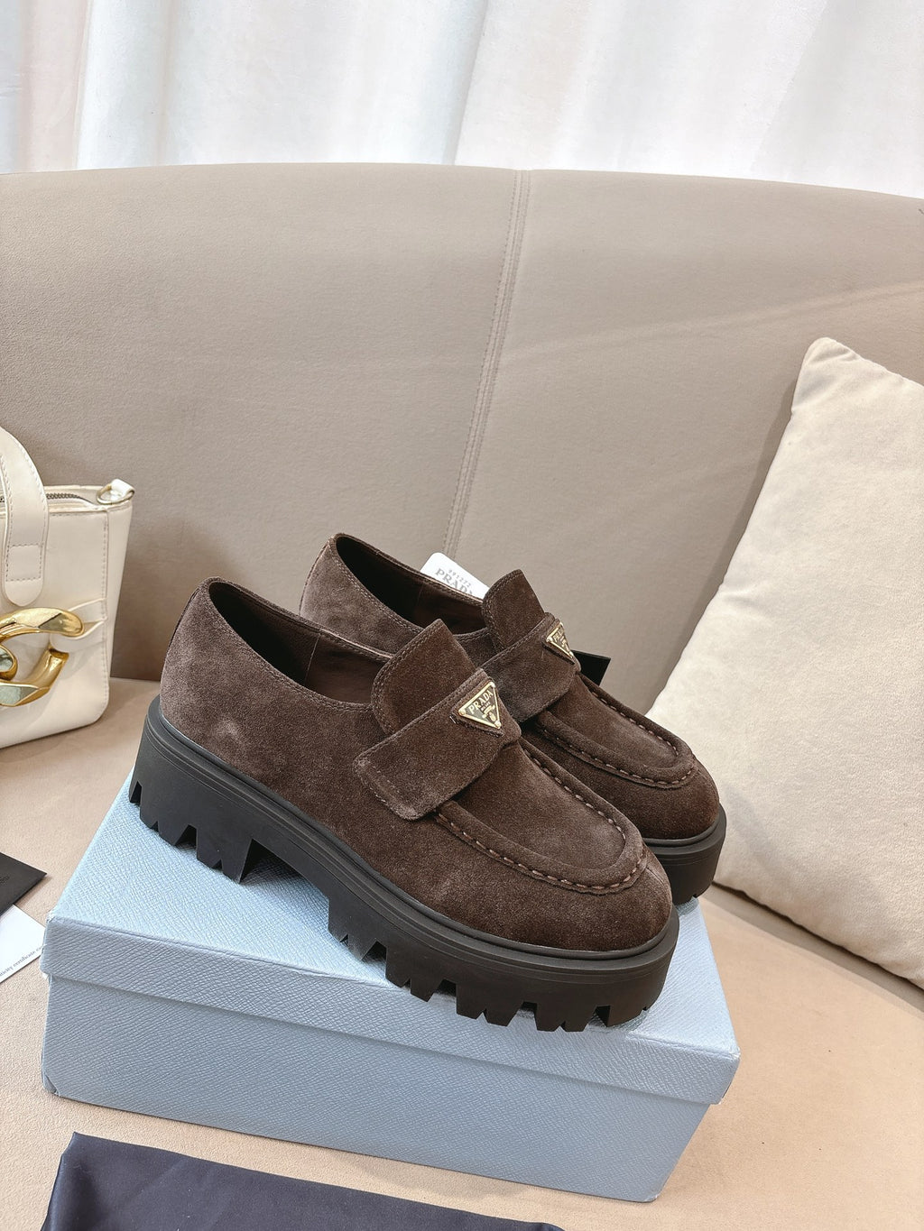 Dark brown suede loafers with buckled strap and squared, chunky lug sole